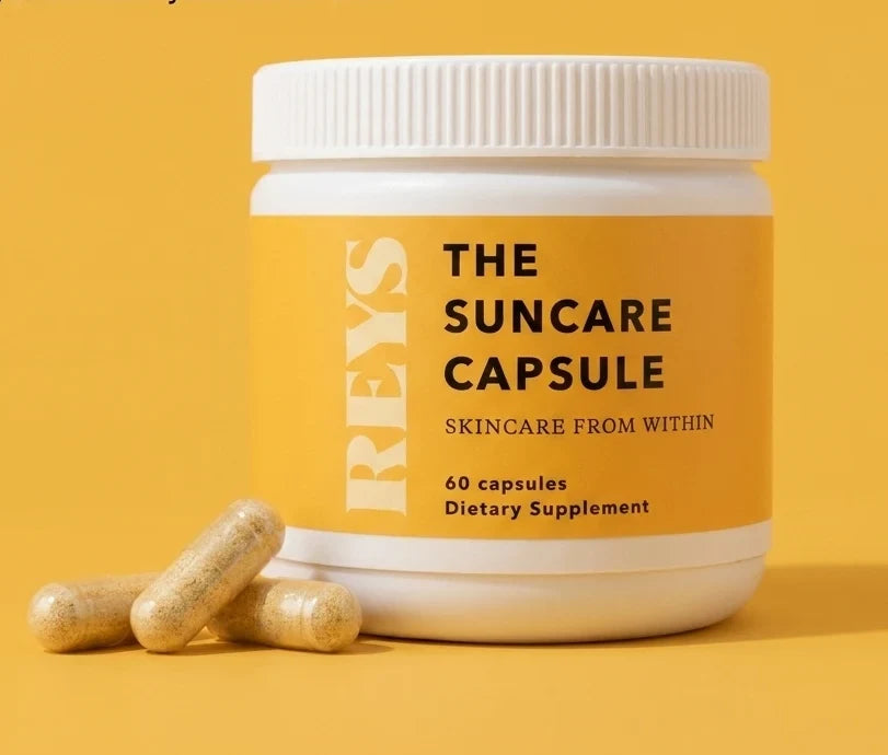 A jar of The REYS Suncare Capsule on a yellow background with three loose capsules