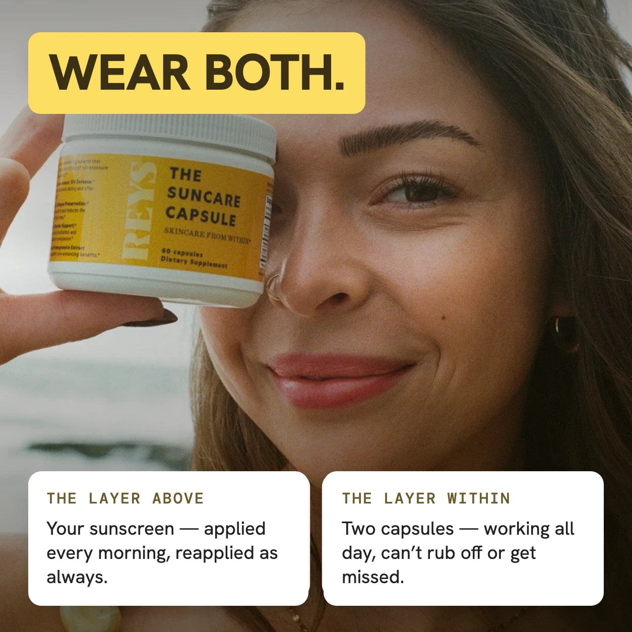 Wear both — the layer above: your sunscreen, applied every morning and reapplied as always; the layer within: two capsules working all day that can’t rub off or get missed; woman holding the REYS jar beside her face